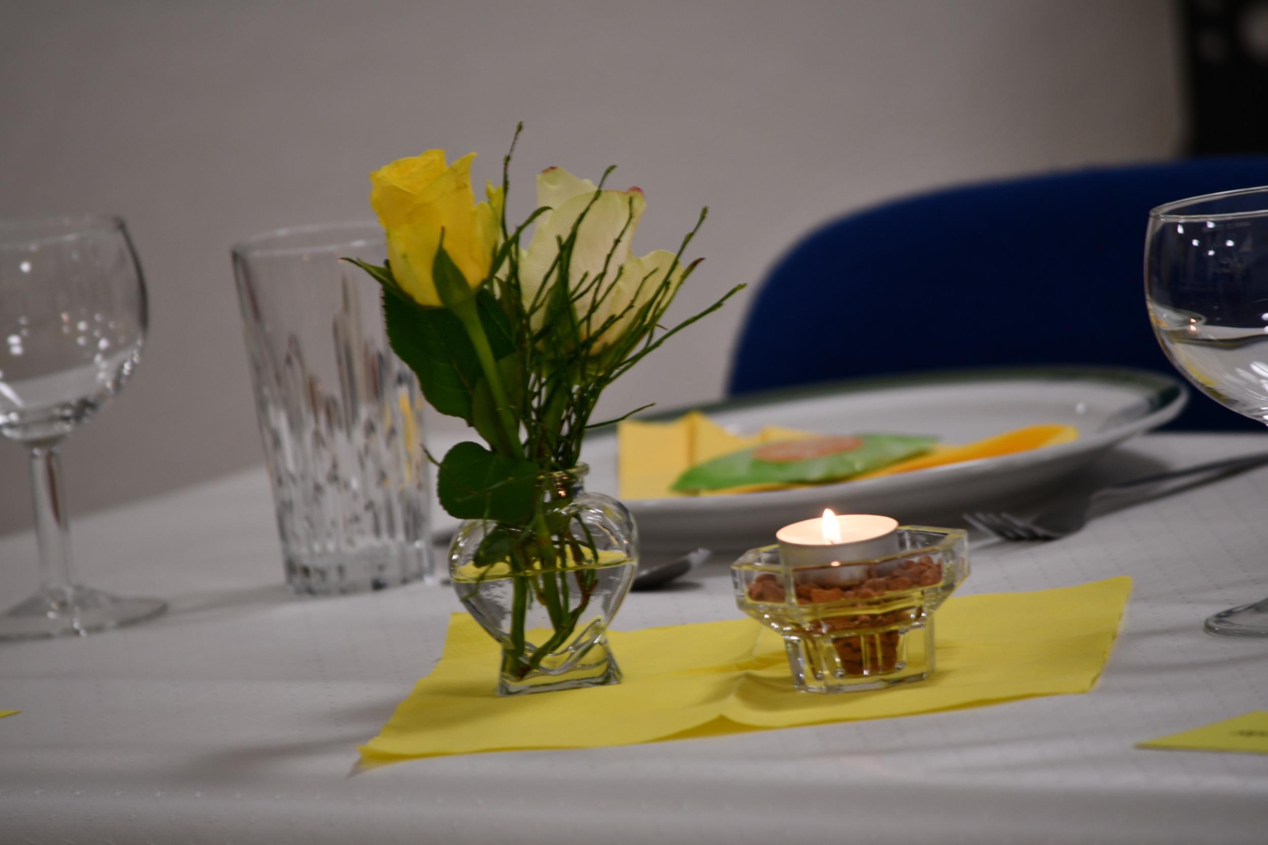 Bild von einem Geburtstagstisch mit Blumenstrauß und Kerze