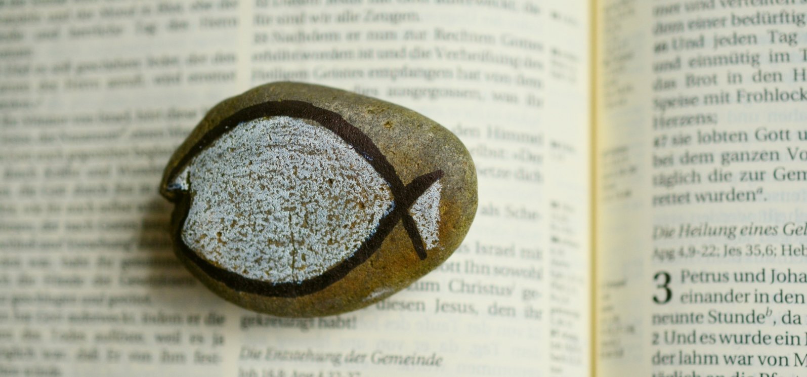 Stein auf Bibel (c) Pfarrbriefservice Stein auf Bibel