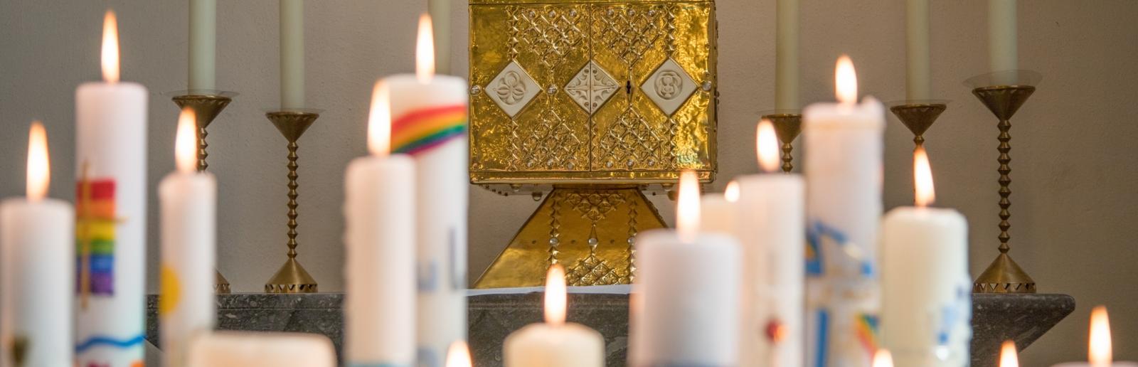 Erstkommunikon in St Pankratius in Köln-Worringen 27.04.2019 Feier der Erstkommunion in St. Pankratius in Köln-Worringen - Brennende Kommunionkerzen vor dem Tabernakel in der Kirche St. Pankratius in Köln-Worringen.
