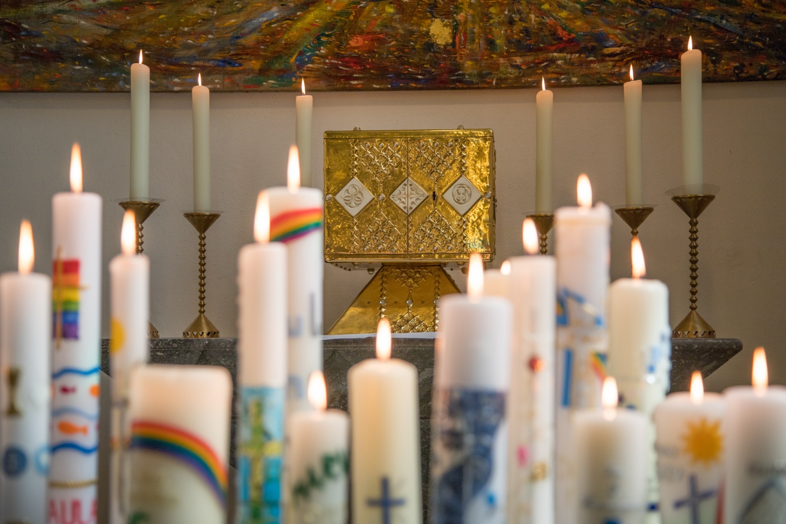27.04.2019 Feier der Erstkommunion in St. Pankratius in Köln-Worringen - Brennende Kommunionkerzen vor dem Tabernakel in der Kirche St. Pankratius in Köln-Worringen.