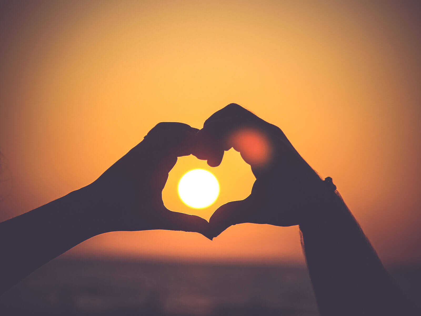 Herz-Händer im Sonnenuntergang